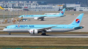 兩架大韓航空飛機在機場跑道上滑行，背景有航站樓。