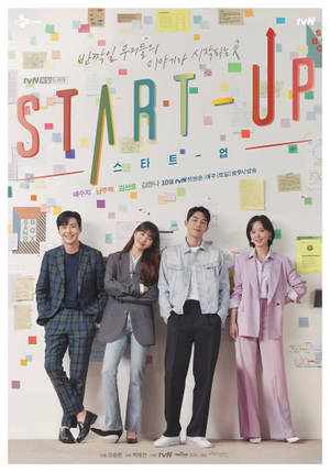 四位演員在貼滿彩色便利貼和標題「START-UP」的牆前擺姿勢。
