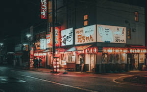日本夜晚的街道，潮濕的人行道上閃爍著霓虹燈招牌和燈籠。 — 夜景城市 壁紙