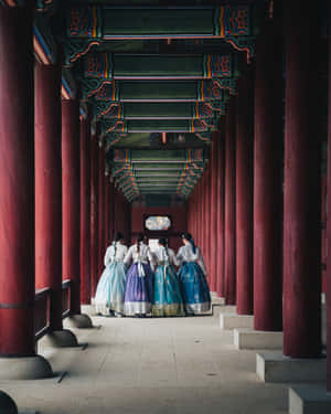 四位身穿傳統韓國韓服嘅女士行過寺廟走廊。 — 韓國 壁紙