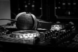 在錄音室環境中，Sennheiser耳機放在DJ混音器上。