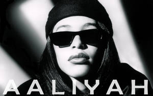 Aaliyah 戴著太陽眼鏡和冷帽，帶有粗體文字疊加。