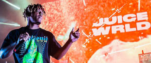 Juice WRLD 在舞台上現場表演，帶有發光的橙色背景和他的名字顯示。