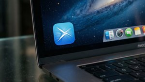 筆記型電腦螢幕顯示Xcode應用程式圖示，背景為星空，並有Dock。