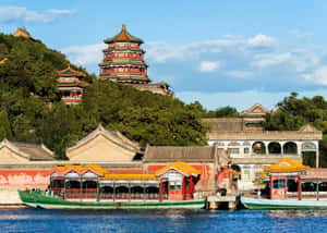 綠色船隻停泊在湖邊的傳統中國宮殿建築群。 — 湖景 壁紙