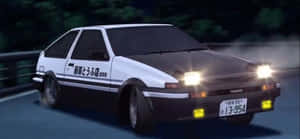 白色和黑色的AE86在夜間潮濕的道路上漂移，車頭燈閃閃發光。