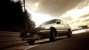銀色AE86賽車在金色日落時分在賽道上飛馳。
