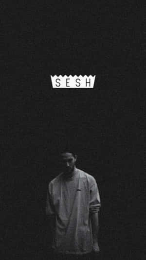 一個人在黑暗的房間裡，'SESH' 這個詞在他們上方發光。