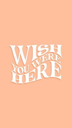 蜜桃色背景上的白色Wish you were here文字