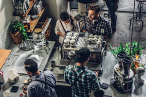 Baristas and customers at a modern coffee shop with marble counters and green plants.