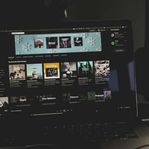 手提電腦屏幕顯示 Spotify 音樂應用程式，帶有冬季播放清單和雪花圖案。