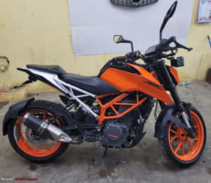 橙色和黑色KTM 390電單車停放在室內混凝土地板上。 — 機車 壁紙