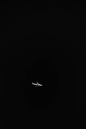一架飛機獨自在黑暗的夜空中飛行。