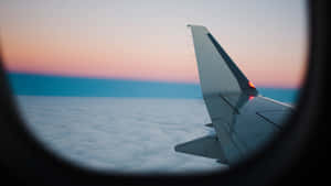 夕陽時從窗戶看到的雲上飛機機翼