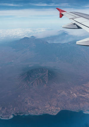 從飛機窗戶俯瞰火山島和海洋
