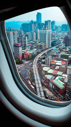 從飛機窗戶俯瞰密集城市的空中景觀，顯示摩天大樓和高架道路。 — 旅行 壁紙