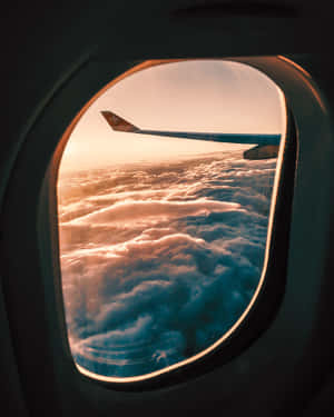 日落雲層上的飛機翼，透過窗戶觀看