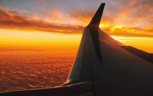 飛機機翼在雲上夕陽中