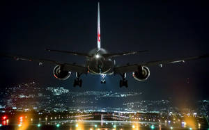夜間飛機在下方城市燈光中降落