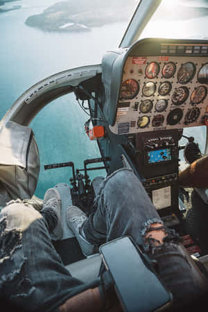 穿破洞牛仔褲的人日落時分駕駛小型飛機飛越海洋。 — 飛機 壁紙