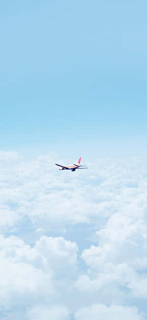 飛機在晴朗藍天的雲海上飛行。 — Pixel 7a 壁紙