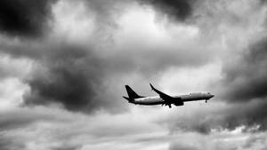 達美航空飛機在黑白中飛過黑暗的風暴雲層。