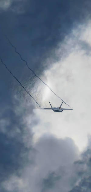 一架戰鬥機在帶有煙跡的多雲天空中飛行。