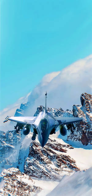 戰鬥機在藍天下低空飛越積雪的山峰