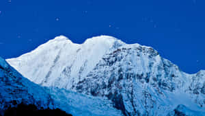 在星空下，深藍色調的雪山山峰。