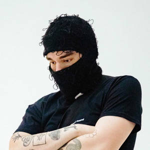 有紋身嘅男人喺影樓戴住黑色巴拉克拉法帽同T恤