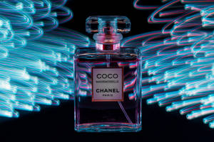 被霓虹光跡包圍的 Chanel Coco Mademoiselle 香水瓶。