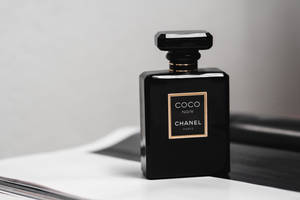 白色表面上的黑色 Chanel Coco Noir 香水瓶，帶有金色標籤。