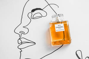 Chanel No 5香水瓶旁邊有一幅黑色線條的女性臉部畫。