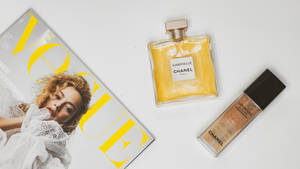 白色背景上的Vogue雜誌和Chanel香水及粉底。