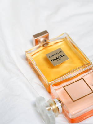兩瓶Chanel Gabrielle香水瓶，金色和桃色液體放在白色布料上。