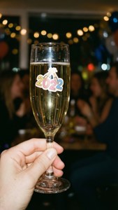 手拿香檳杯，杯上有2022年貼紙，在除夕派對中