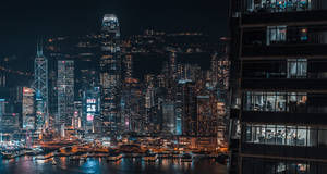 夜間香港天際線，閃爍的摩天大樓和港口倒影。