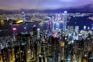 香港夜景，發光的摩天大樓和港灣燈光。 — MacBook Pro M2 壁紙