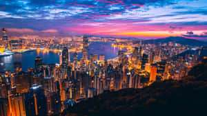 暮色中的香港城市景觀，建築物閃爍，天空色彩繽紛 — 暮光 壁紙