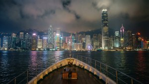 從船上觀看香港燈火通明的天際線橫跨水面的夜景。