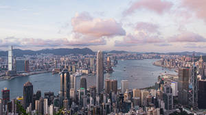 香港天際線日落，粉紅雲朵與海港船隻