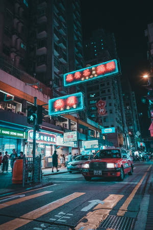 夜晚城市街道，有發光嘅霓虹招牌同紅色嘅士。 — 霓虹 壁紙