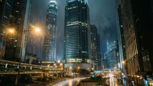 雨夜城市景觀，發光的摩天大樓和濕漉漉的街道反射燈光。