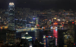 香港夜景，燈火通明的摩天大樓和水面倒影。