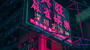 霓虹燈在夜間用粉紅色和藍綠色的燈光照亮城市建築。 — 唐人街 GIF 壁紙