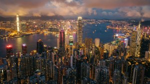 黃昏時分的香港城市景觀，燈火通明的摩天大樓和港灣水面。 — 香港 壁紙