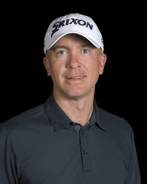 專業高爾夫球手戴著白色Srixon帽和深色Polo衫，背景為黑色。 — 4:5 壁紙