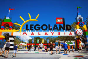 色彩繽紛的LEGO馬來西亞主題公園入口，家庭在明亮的藍天下漫步。