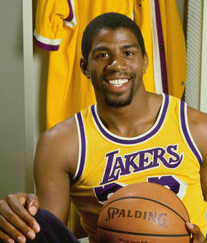 身穿湖人隊球衣的籃球運動員在更衣室裡拿著 Spalding 籃球。