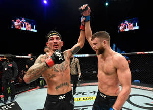 兩名MMA拳手在UFC八角籠內舉手慶祝勝利。